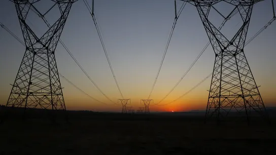 Amanecer tras unas torres eléctricas en una imagen de archivo Amanecer tras unas torres eléctricas en una imagen de archivo