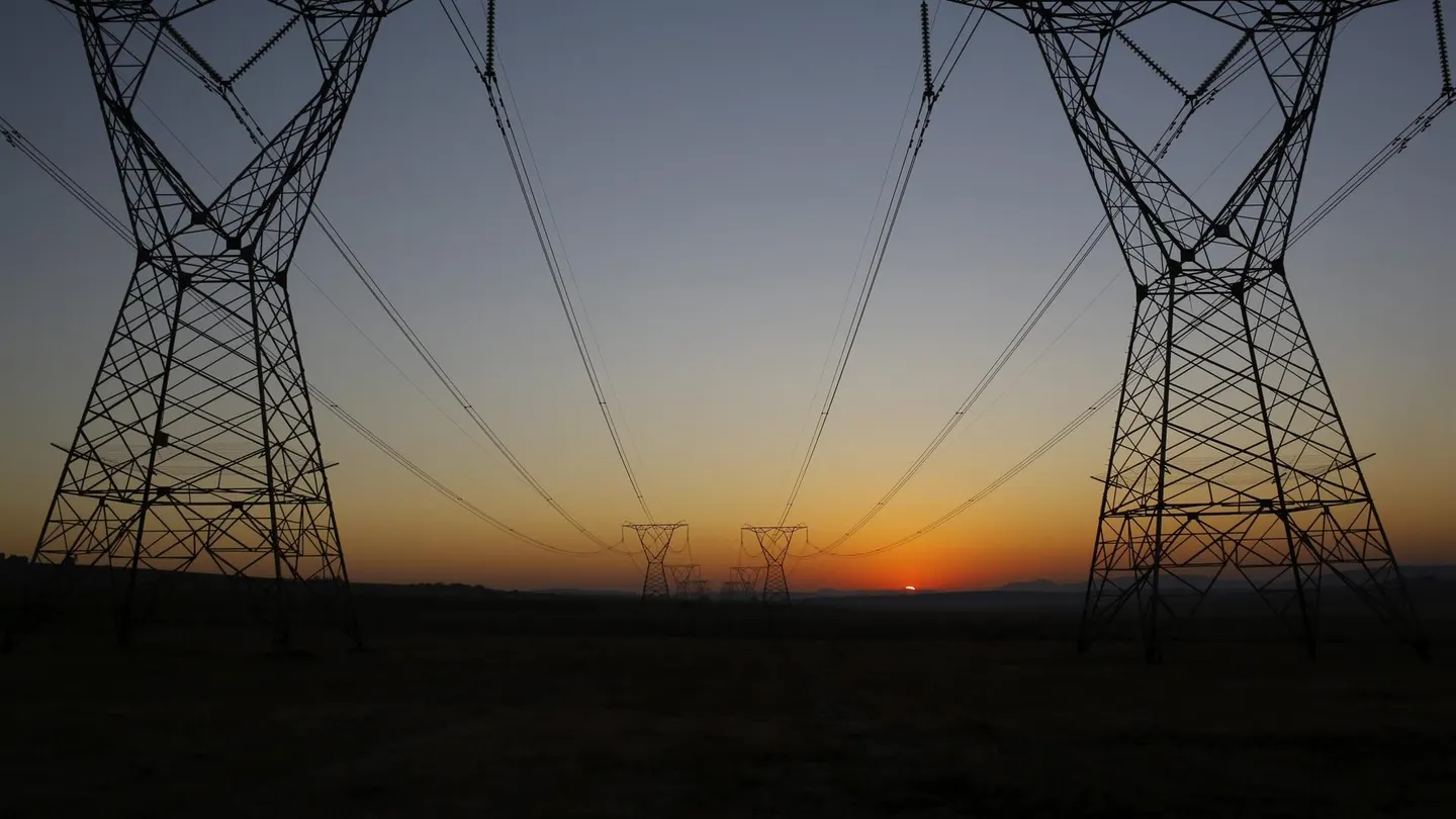 Amanecer tras unas torres eléctricas en una imagen de archivo Amanecer tras unas torres eléctricas en una imagen de archivo