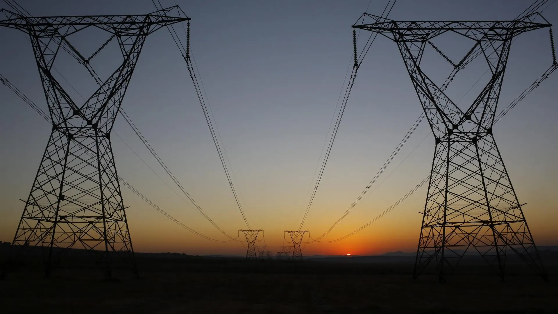 Amanecer tras unas torres eléctricas en una imagen de archivo