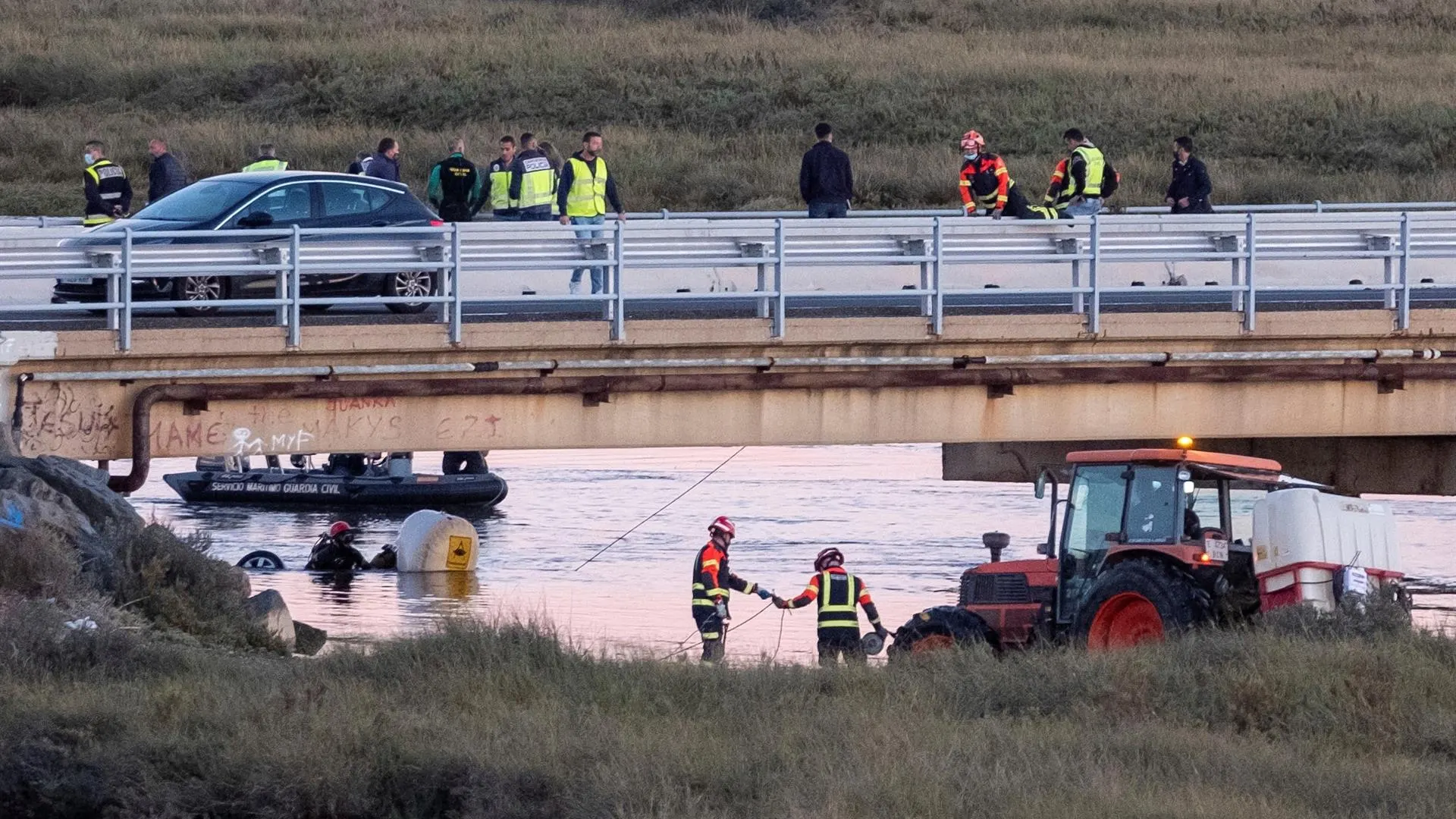 Dispositivo policial tras encontrarse un vehículo hundido en el río cerca de uno de los desvíos de la salida de Huelva capital hacia la playa de El Espigón.