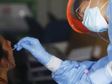 Un sanitario realiza una PCR a un paciente.