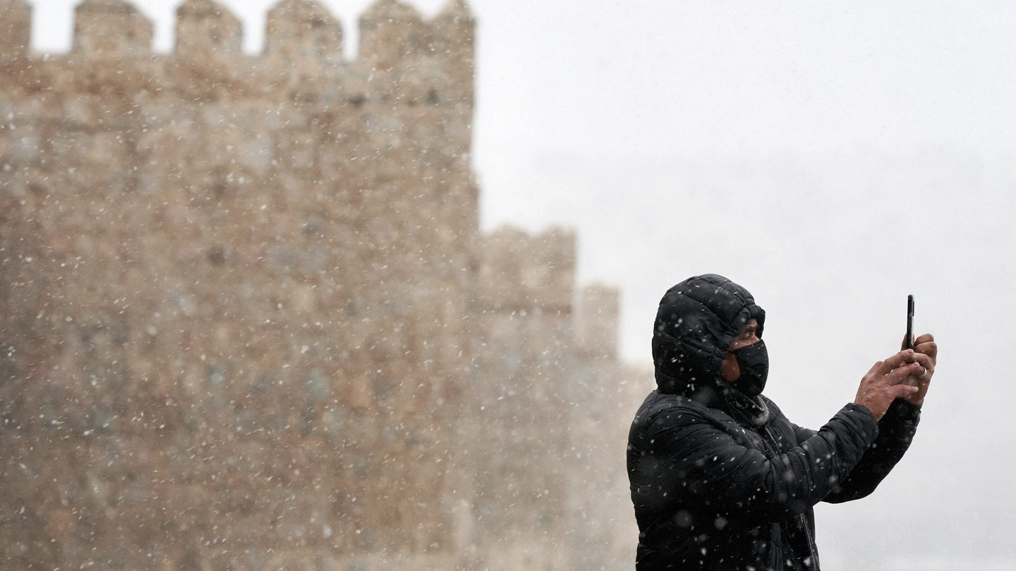 Un hombre se hace una foto con su teléfono móvil junto a la muralla de Ávila durante la primera nevada del otoño en la capital abulense. Un hombre se hace una foto con su teléfono móvil junto a la muralla de Ávila durante la primera nevada del otoño en la capital abulense.
