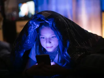 Un adolescente mira su móvil poco antes de irse a dormir. Un adolescente mira su móvil poco antes de irse a dormir.