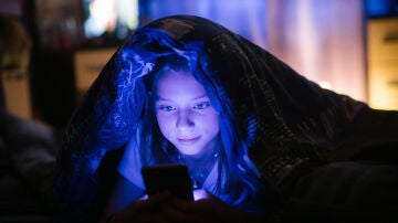 Un adolescente mira su móvil poco antes de irse a dormir.
