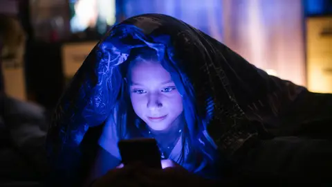 Un adolescente mira su móvil poco antes de irse a dormir. Un adolescente mira su móvil poco antes de irse a dormir.