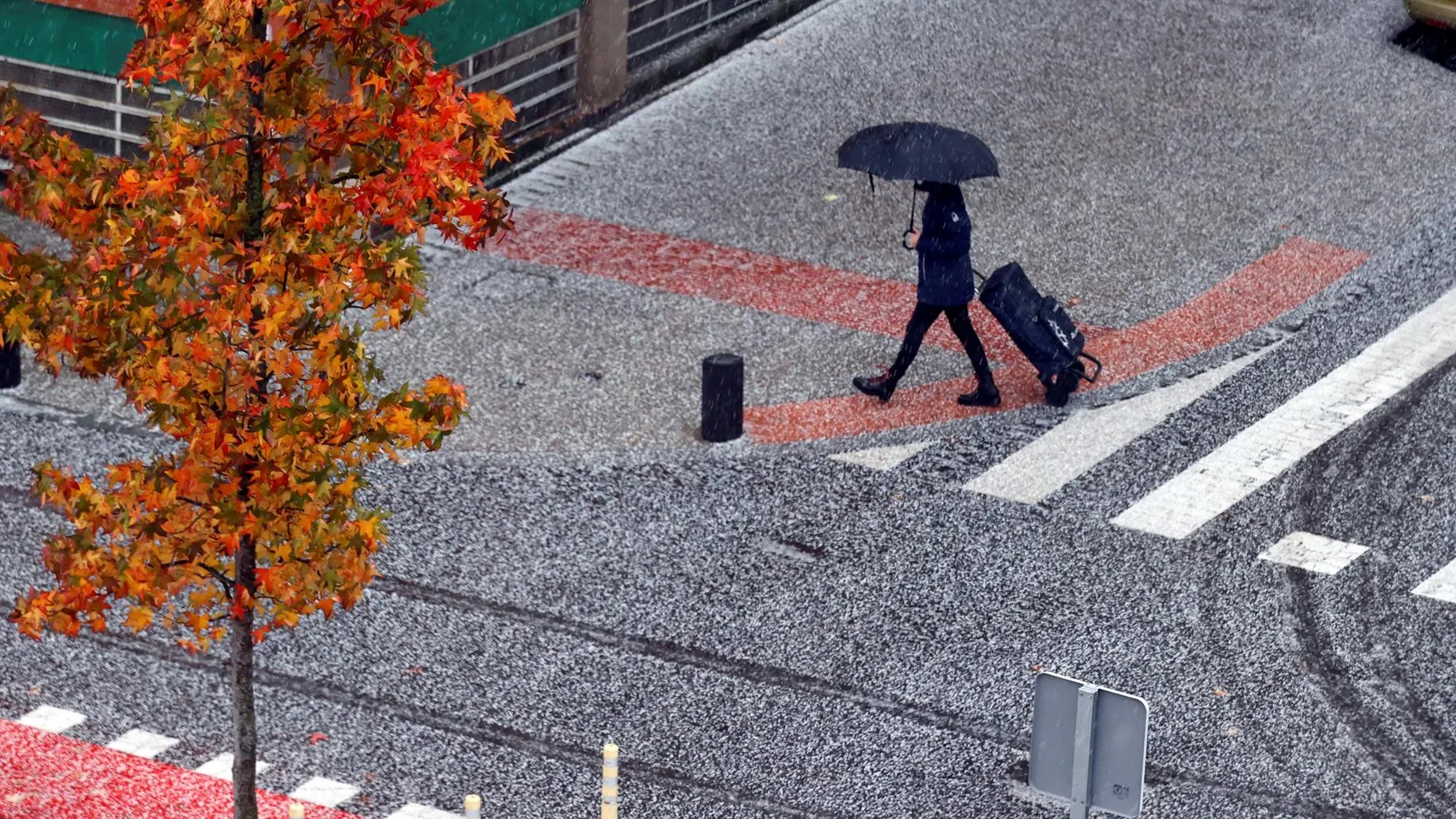 Un viandante camina entre el granizo y la lluvia en una imagen de archivo