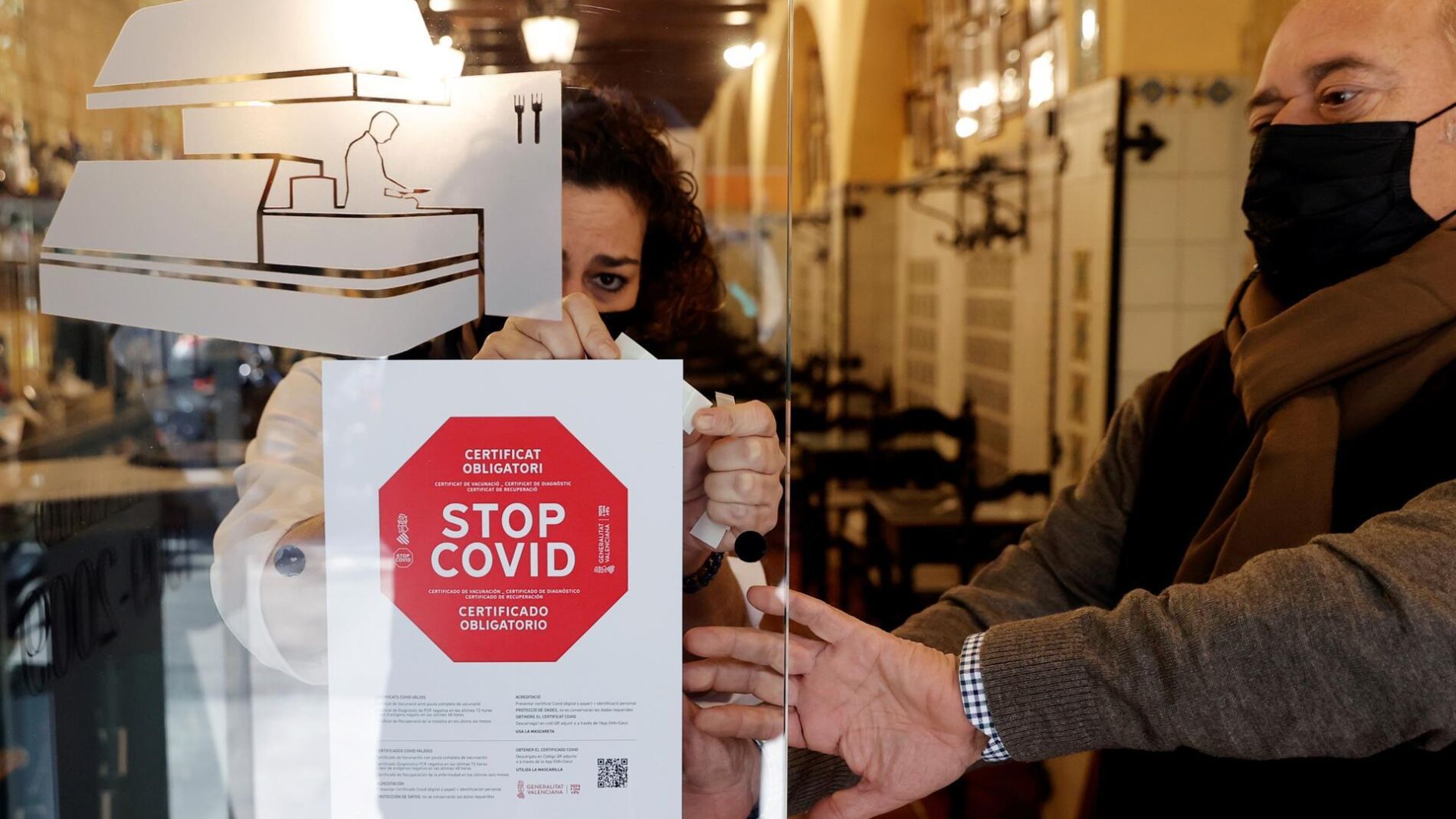 Personal de un hotel coloca un cartel a la entrada de su restaurante avisando de la obligatoriedad del pasaporte covid