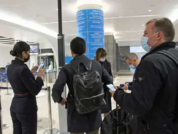 Varios pasajeros muestran su pasaporte COVID en el aeropuerto de Roma-Fiumicino.