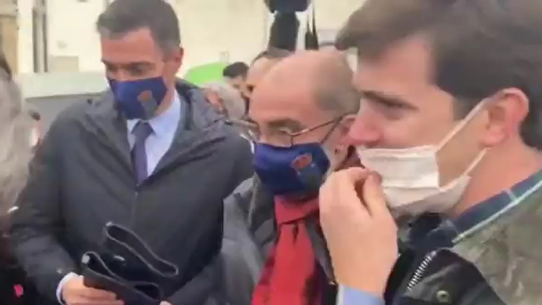 Imagen del momento en el que el líder del PP de Zaragoza le entrega las botas de agua al presidente del Gobierno.