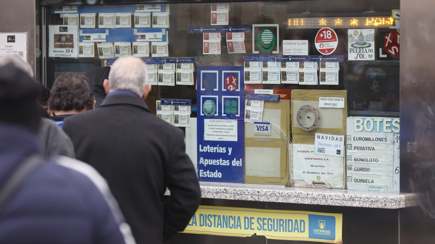 Varias personas en una administración de lotería de Navidad de la Puerta del Sol Varias personas en una administración de lotería de Navidad de la Puerta del Sol