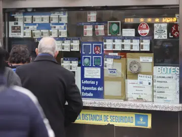 Varias personas en una administración de lotería de Navidad de la Puerta del Sol