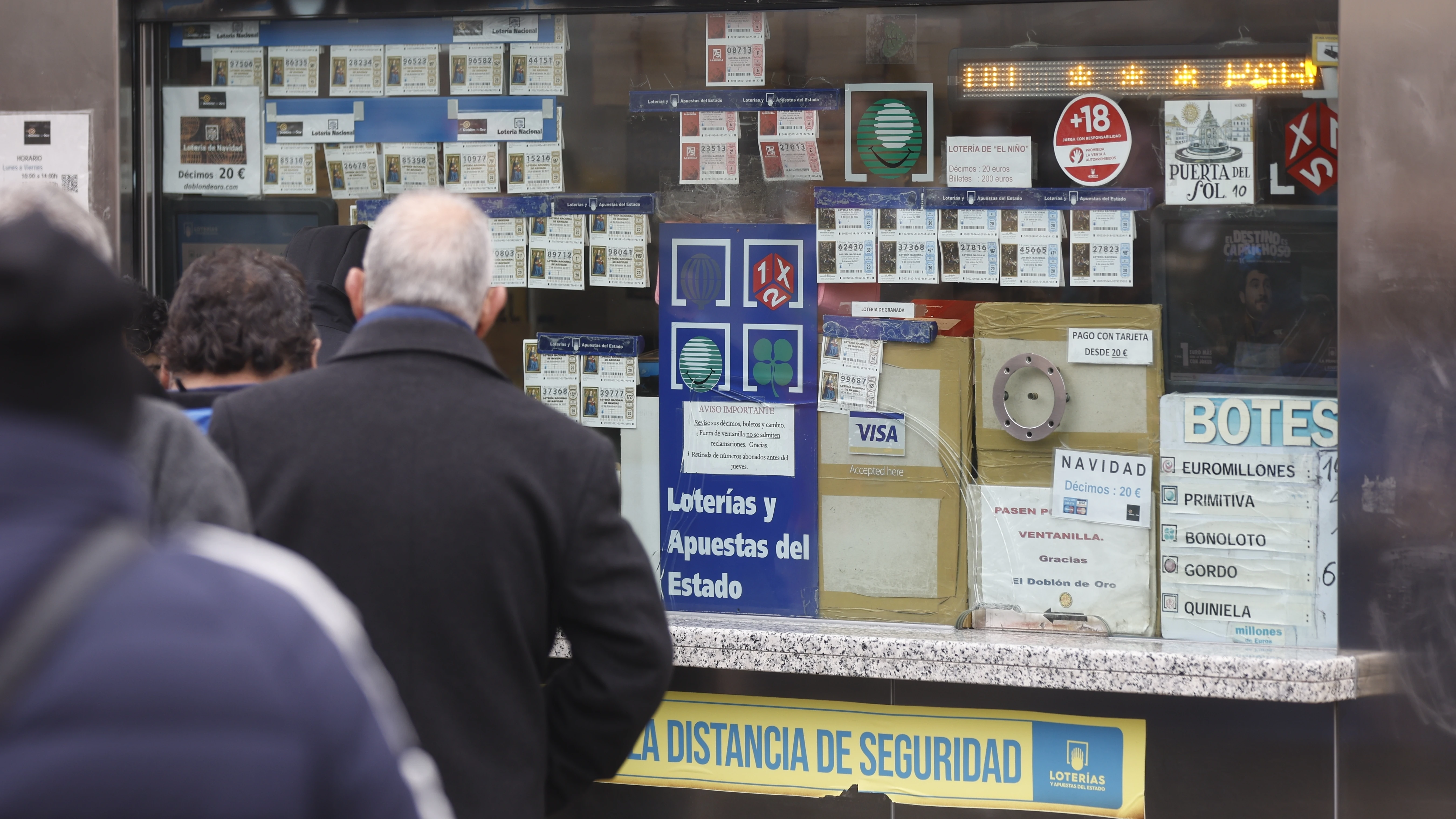 Varias personas en una administración de lotería de Navidad de la Puerta del Sol