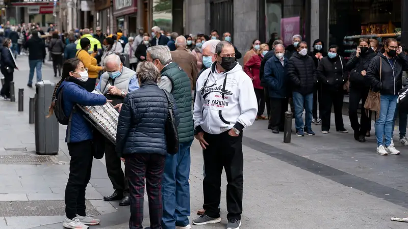 Un grupo de personas esperan a las puertas de la administración de lotería Doña Manolita
