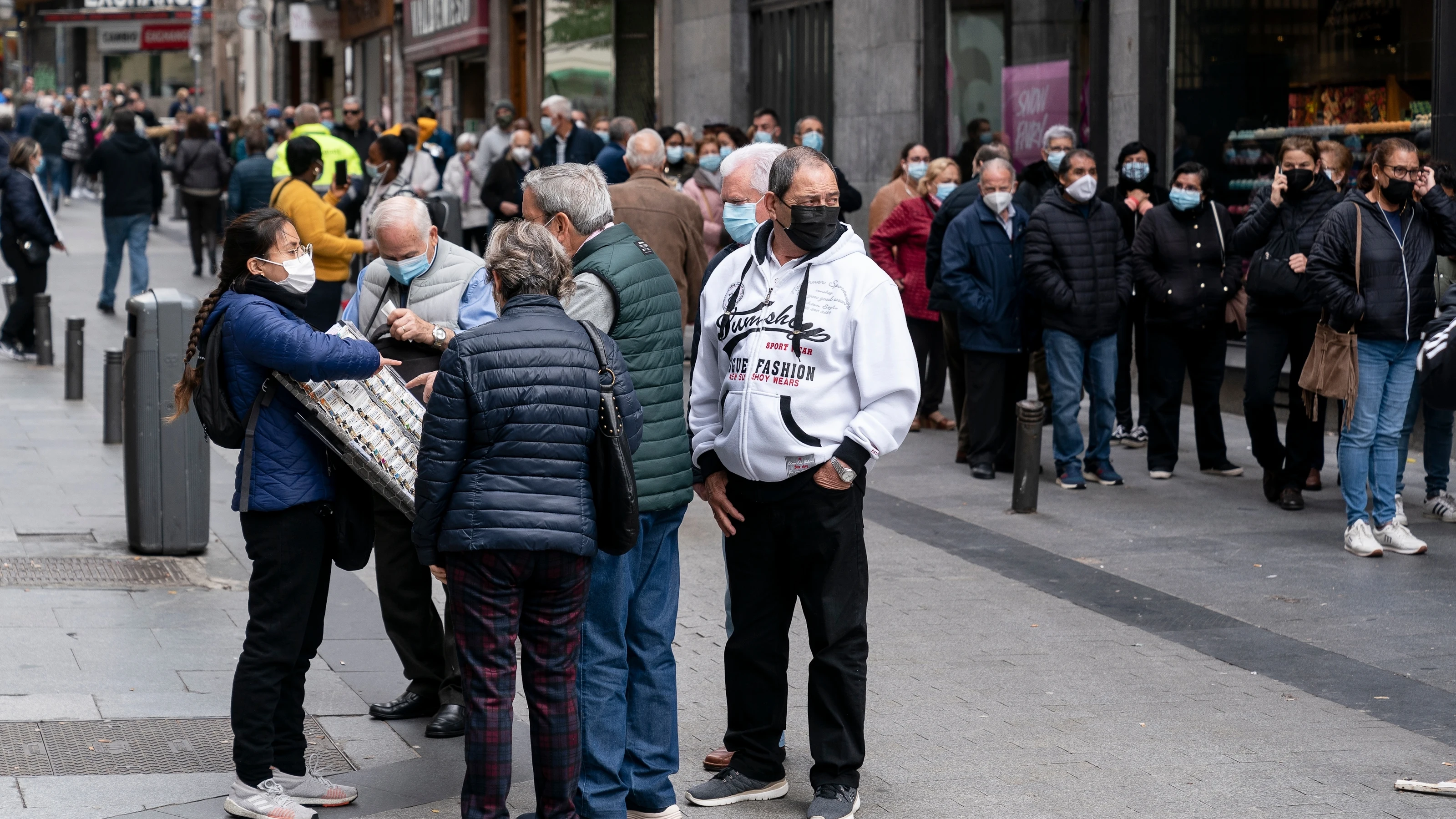 Un grupo de personas esperan a las puertas de la administración de lotería Doña Manolita