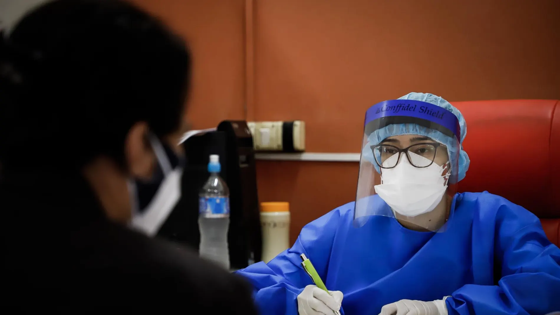 Una enfermera toma los datos de una persona con síntomas de COVID-19 en un hospital de Paraguay