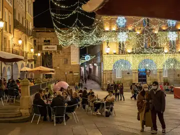 Varias personas sentadas en una terraza de una cafetería en la Plaza Mayor, en Ourense.
