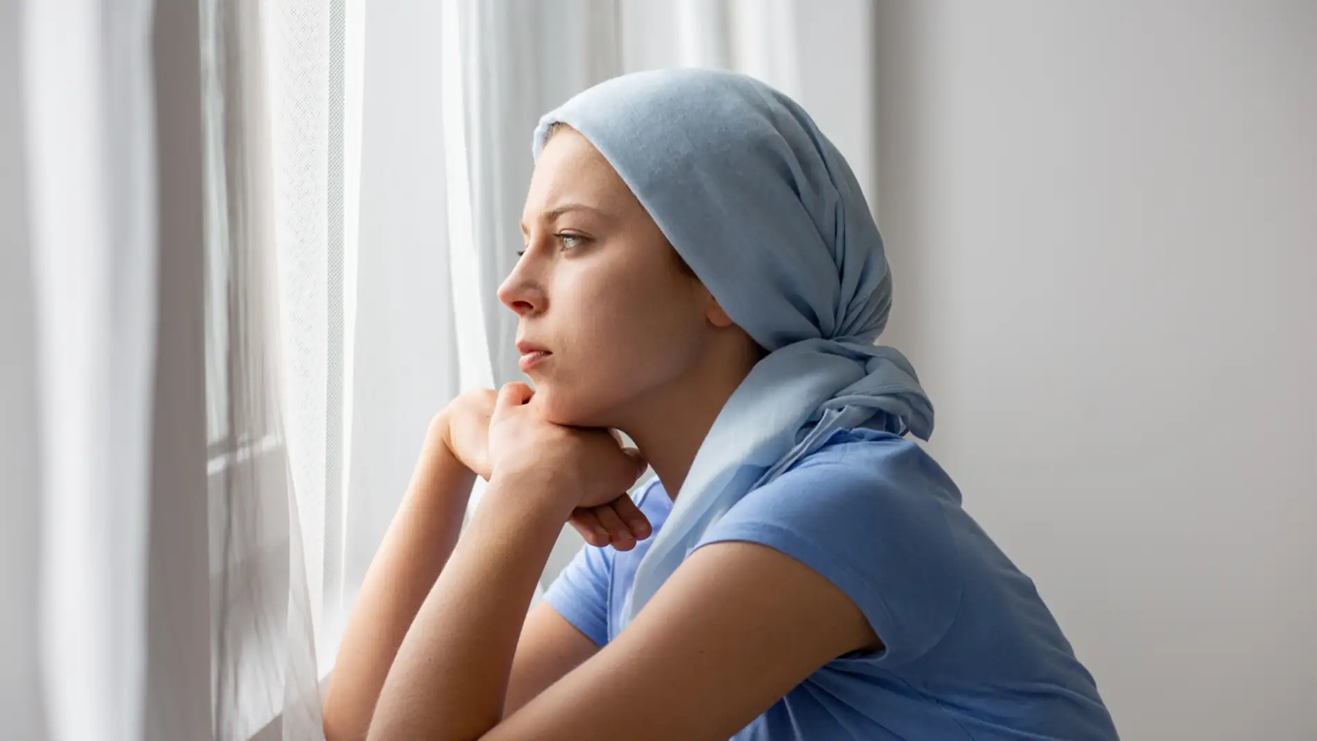 mujer con cáncer mirando por la ventana