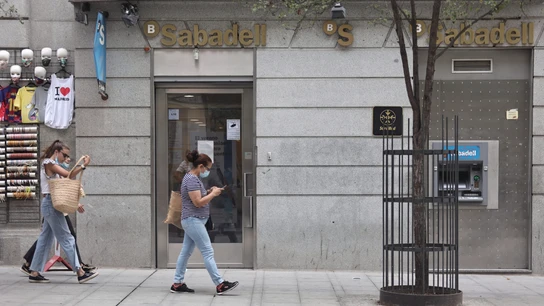 Varias personas pasan por una sucursal de Banco Sabadell en Madrid (España) Varias personas pasan por una sucursal de Banco Sabadell en Madrid (España)