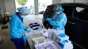 Dos enfermeras preparan el test en una mesa durante la realización de PCR en el autocovid instalado en el Hospital Militar de Sevilla.