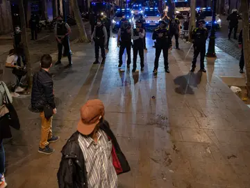 Varios jóvenes frente a un grupo de policías en Barcelona