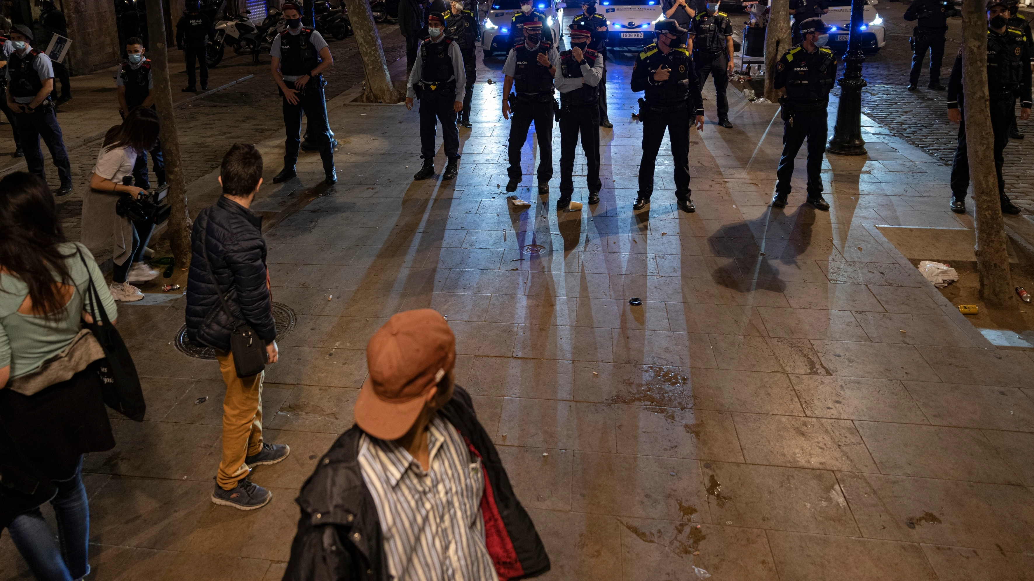 Varios jóvenes frente a un grupo de policías en Barcelona