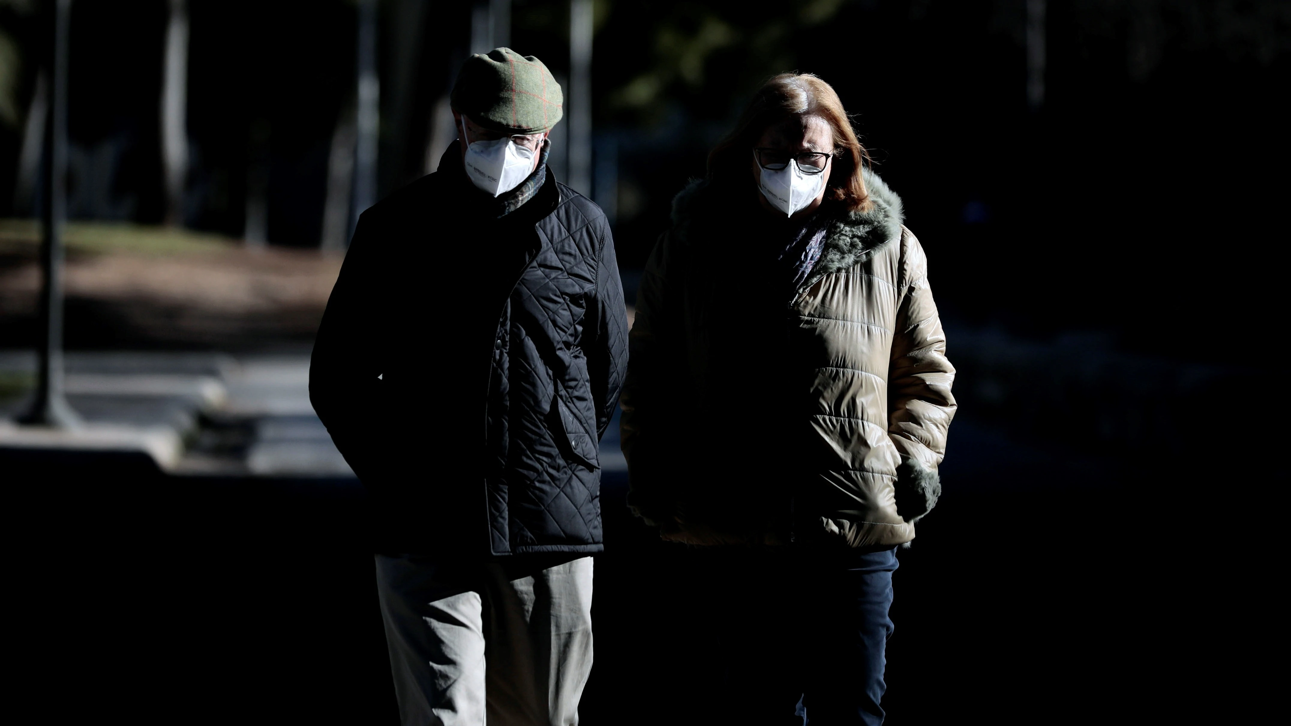 Dos personas pasean abrigadas y con la mascarilla puesta