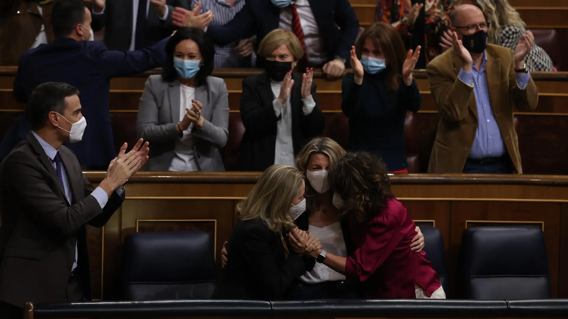 Pedro Sánchez, Nadia Calviño, Yolanda Díaz y María Jesús Montero, aplauden y se abrazan después de que el pleno del Congreso 