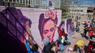 Varias personas pintan de nuevo el mural feminista de Unlogic Crew junto a la estación de Getafe Central, en Getafe, Madrid