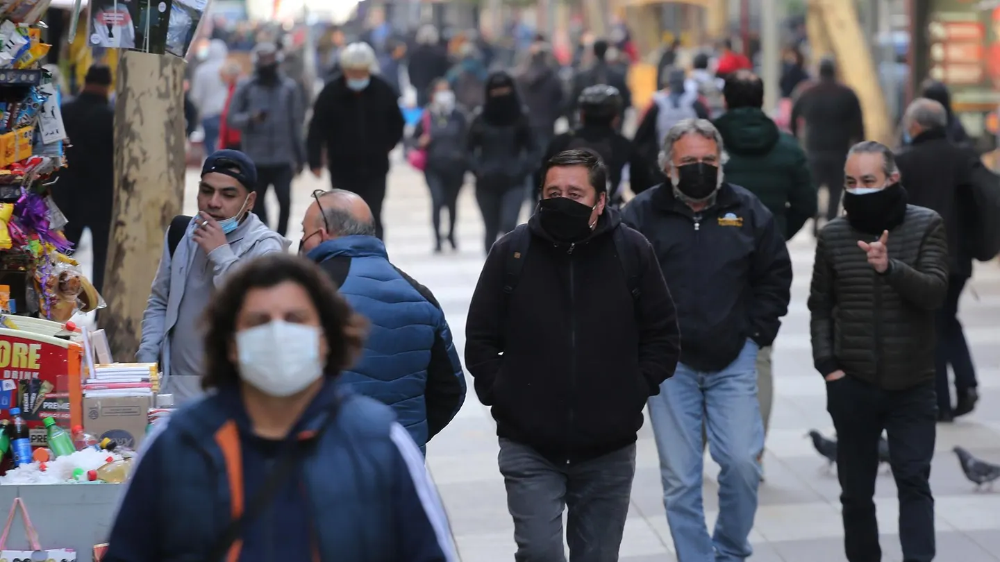 Varias personas pasean por la calle con mascarilla. Varias personas pasean por la calle con mascarilla.