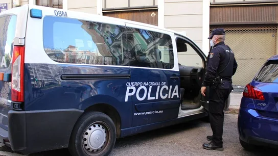 Un agente y un coche de la Policía Nacional Un agente y un coche de la Policía Nacional