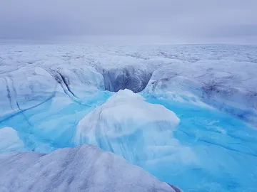 Agua fluyendo hacia una grieta y bajando al lecho del glaciar Store, en Groenlandia Agua fluyendo hacia una grieta y bajando al lecho del glaciar Store, en Groenlandia