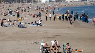 Varias personas tomando el sol en la playa de Las Arenas de Valencia