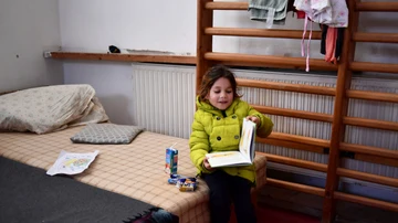 Una niña lee un libro en un refugio en la frontera de Hungría