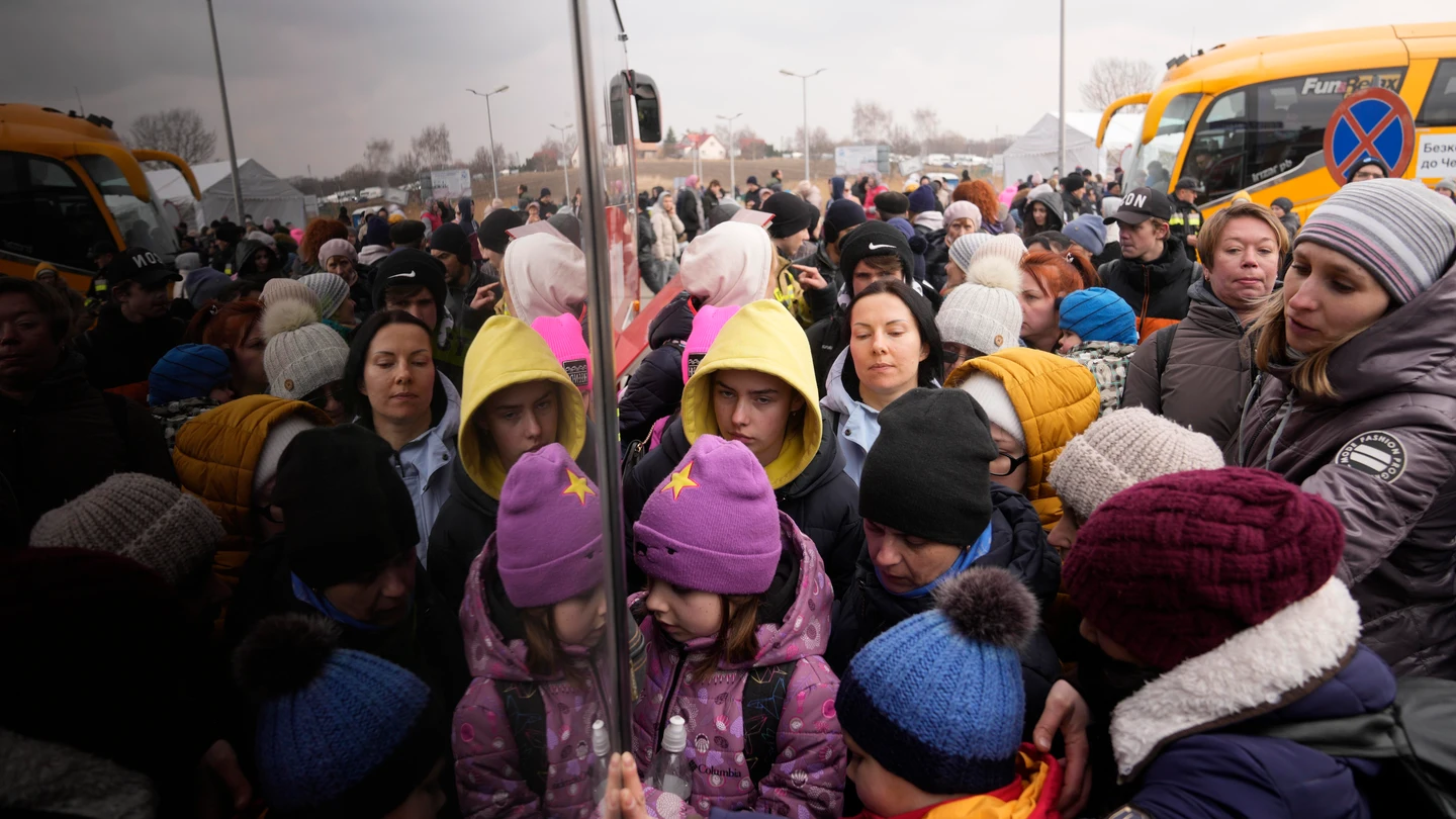 Personas que huyen de Ucrania hacen cola para abordar un autobús en el cruce fronterizo en Medyka, Polonia Personas que huyen de Ucrania hacen cola para abordar un autobús en el cruce fronterizo en Medyka, Polonia
