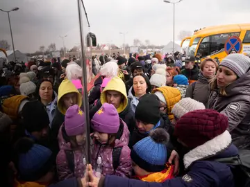Personas que huyen de Ucrania hacen cola para abordar un autobús en el cruce fronterizo en Medyka, Polonia
