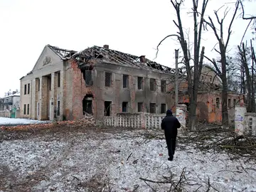 Un hombre pasea frente a un edificio derruido Kharkiv