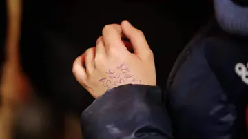 La mano del niño ucraniano de 11 años con el número de teléfono