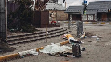 Los cadáveres de personas muertas por bombardeos rusos yacen cubiertos en la calle en la ciudad de Irpin, Ucrania.