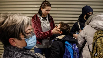 Una mujer acaricia a un menor a su llegada a Valencia.