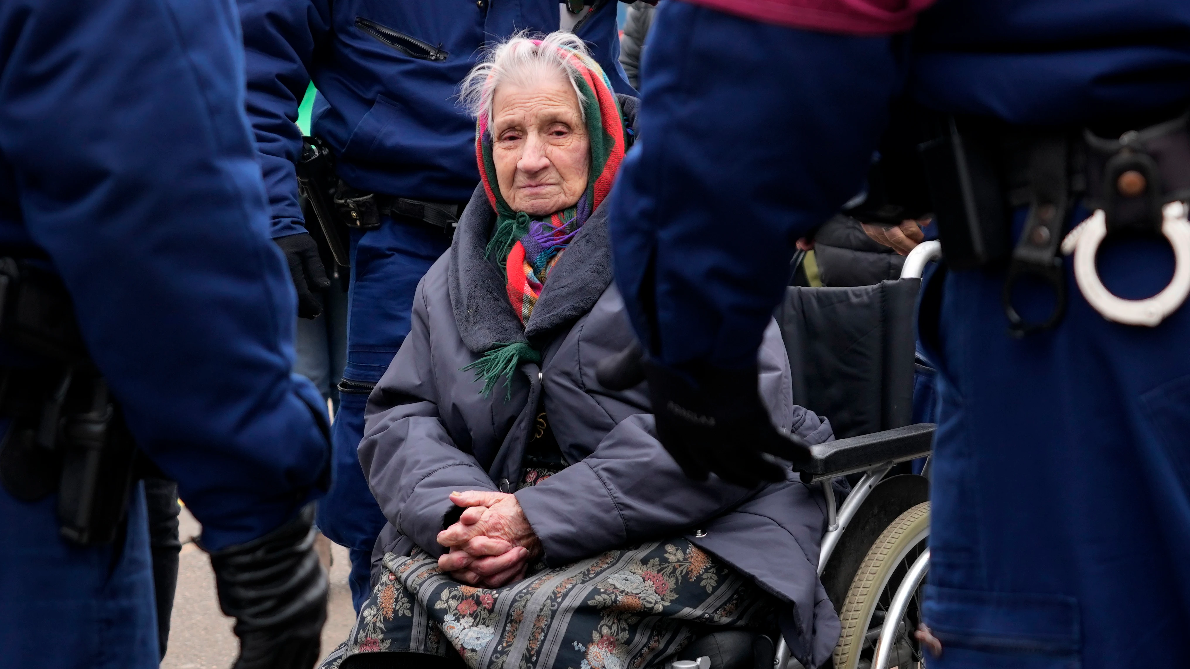 Una anciana que huyó de Ucrania está en una silla de ruedas esperando ayuda después de llegar a la estación de tren de Zakhon, Hungría.