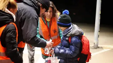 Los voluntarios de Eslovaquia recibiendo al niño y dándole agua y comida