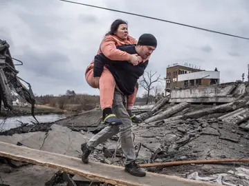 Dos ciudadanos huyen de la ciudad de Irpin, en Ucrania