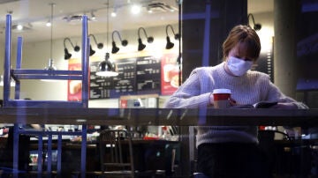 Una mujer con la mascarilla puesta en el interior de un local