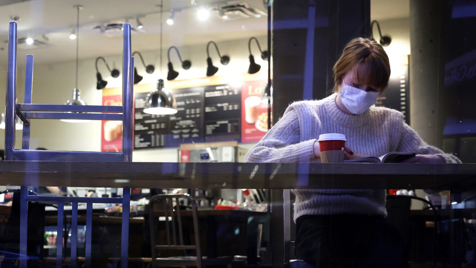 Una mujer con la mascarilla puesta en el interior de un local