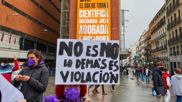 Una mujer sostiene una pancarta donde se lee &quot;No es no, lo demás es violación&quot;, durante un acto simbólico del Movimiento Feminista de Madrid en la Plaza de Callao, en Madrid (España), a 8 de marzo de 2021.