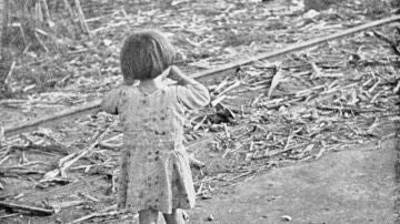 Una niña junto a su muñeco en 'La Desbandá'