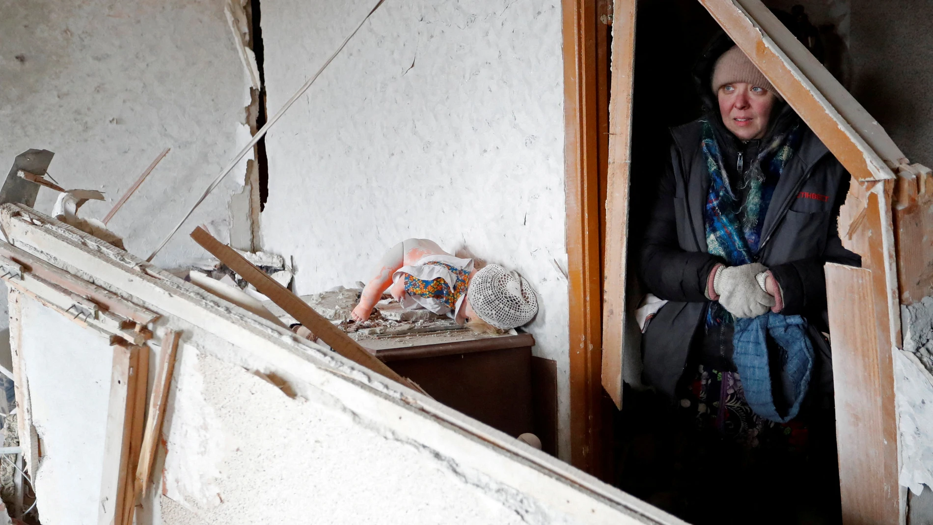 Una mujer se refugia bajo una casa en ruinas en Mariúpol