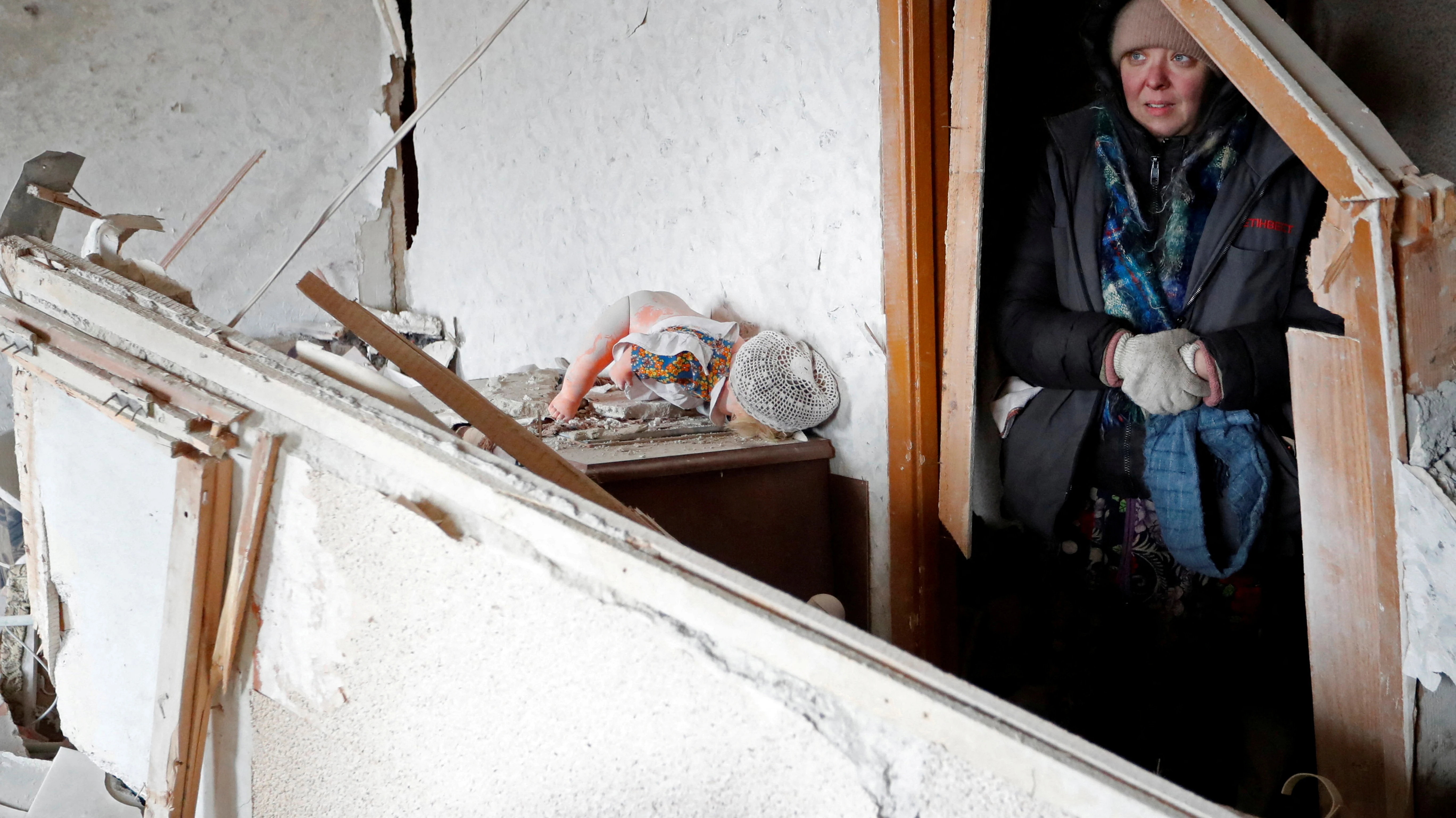 Una mujer se refugia bajo una casa en ruinas en Mariúpol