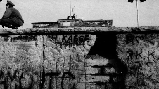 Porción del Muro de Berlín, en parte destruida, vista desde el lado occidental, con un guardia fronterizo y la Puerta de Brandeburgo al fondo, noviembre de 1989. Porción del Muro de Berlín, en parte destruida, vista desde el lado occidental, con un guardia fronterizo y la Puerta de Brandeburgo al fondo, noviembre de 1989.