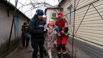 El fotógrafo de Associated Press Evgeniy Maloletka ayuda a un paramédico a transportar a una mujer herida durante un bombardeo en Mariupol